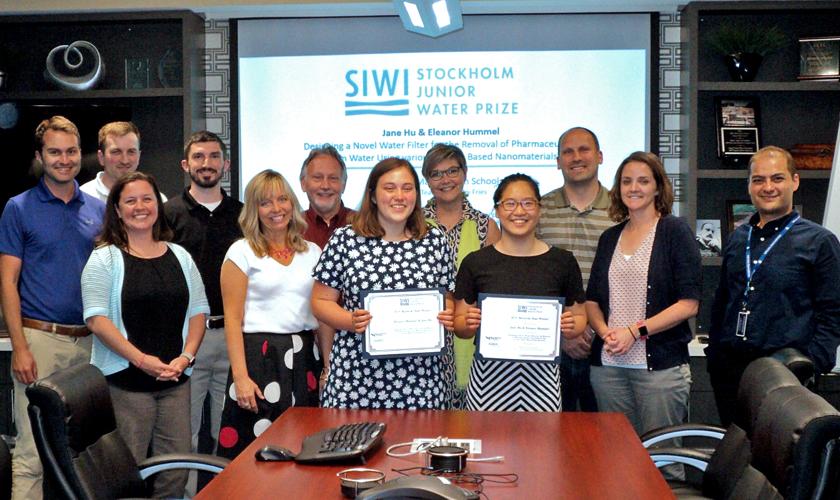 Ellie Hummel and Jane Hu, at center, left and right, respectively, hold their SJWP certificates. Attending the ceremony were Valerie Lucas, representing KY-TN WEA, at Ms. Hummel's left; Kay Sanborn, representing KY/TN AWWA, back row between the prize winners, and Milad Ebrahimi, representing Louisville MSD, far right. Louisville office team members shown include, from left, Tyler Bridges, Nick Gunselman, Shanna Stone, Josh Flanery, Robert Bates, Joe Pavoni, and Adalyn Haney. 